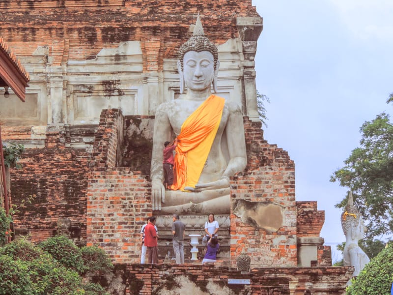 people at a large statue in Ayutthaya, one of the things to do in Bangkok