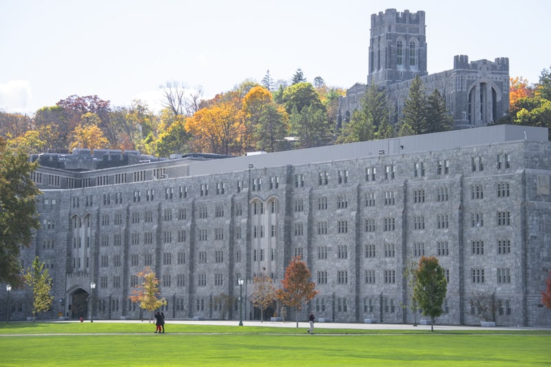 people walking past large stone buildings in the Hudson Valley