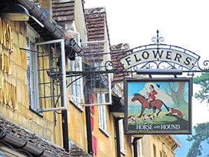a sign for a flower shop by a yellow building seen on day trips from London 