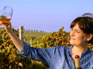 a woman looking at a wine glass