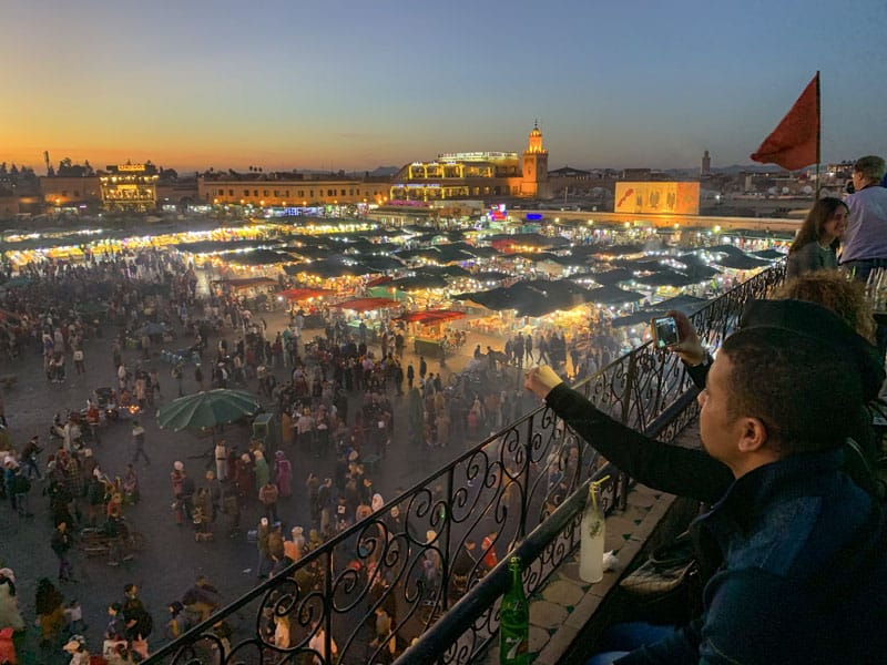 people enjoying the evening at the Jemaa-el-Fna, one of the things to do in Marrakesh