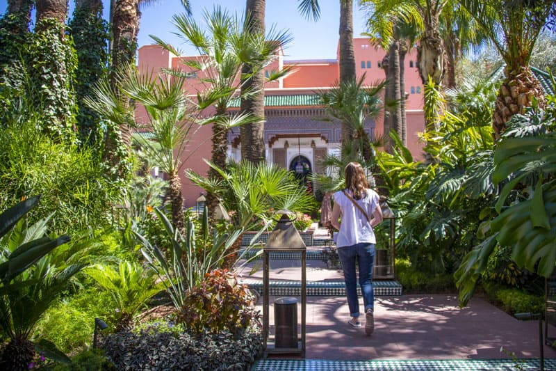 a woman walking towards a pink building