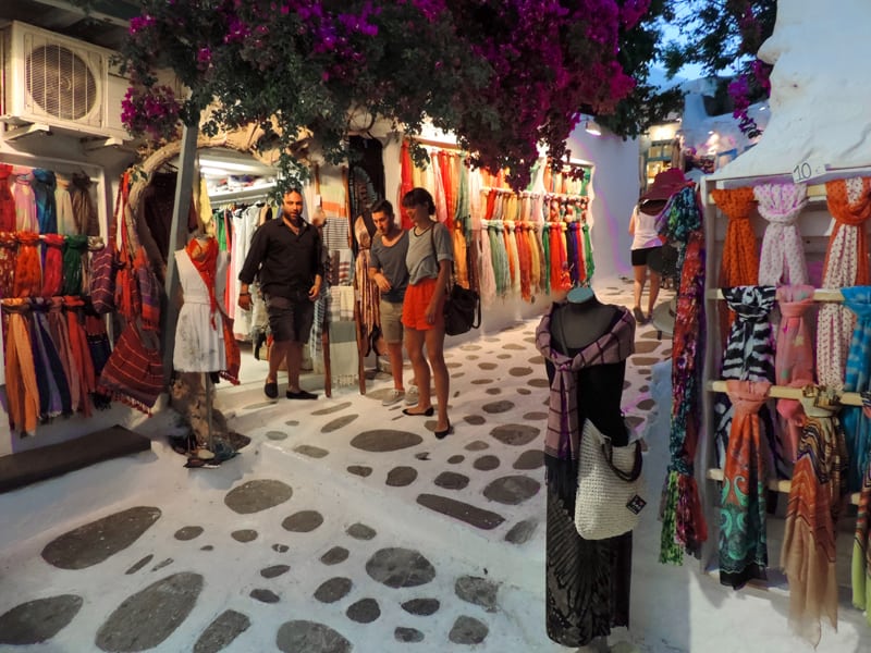 people outside a colorful boutique in old town Mykonos 