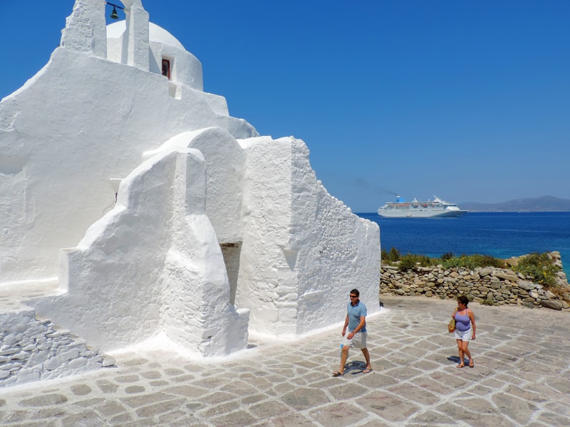 a white building with a cruise ship in the distance