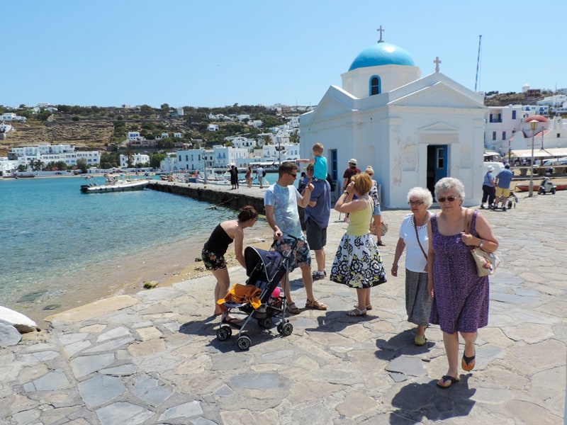 people walking by a small chapel