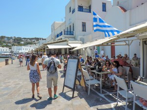 a large Greek flag flying over a restaurant