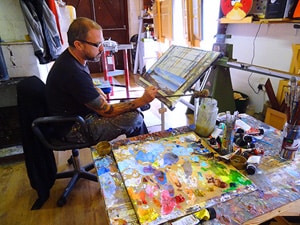 a painter sitting at an easel