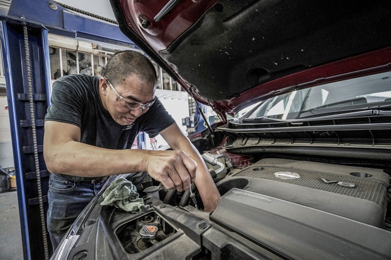 mechanic servicing a car for a best road trip