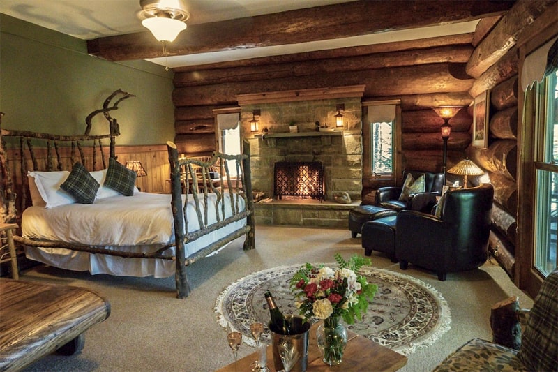 A large bedroom with walls of logs at the Trout Point Lodge