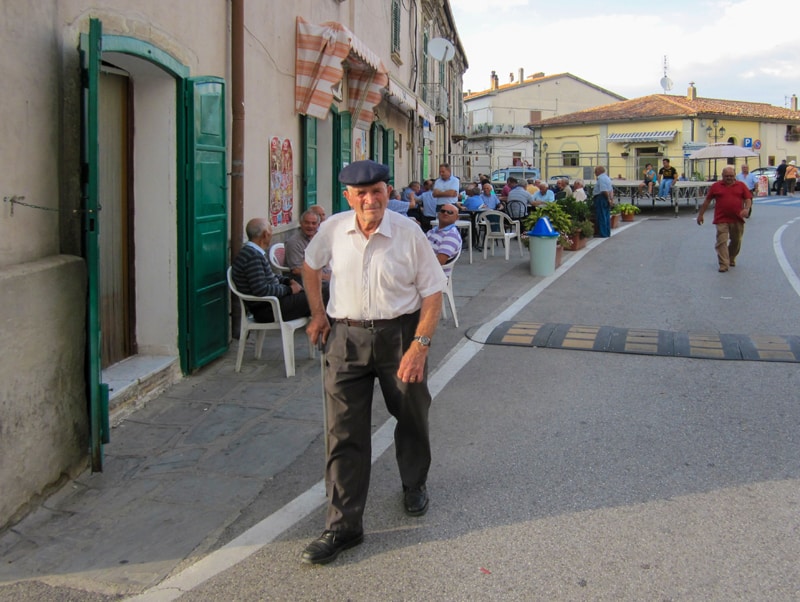 man with a blue cap walking along a road