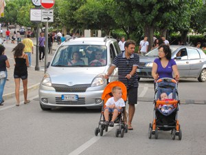 people in the street with baby carriages