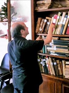 a priest at a bookcase