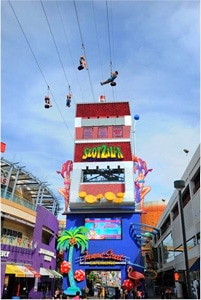 people on a zip line between city buildings