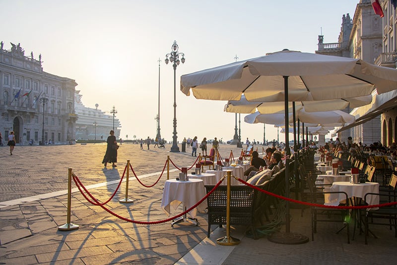 people at a cafe near a cruise ship in Friuli Venezia Giulia