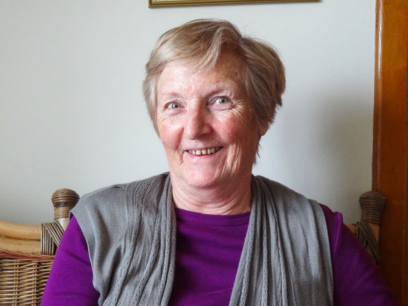 a woman in a purple blouse smiling