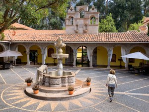woman walking by an old fountain seen in Cusco and the Sacred Valley in Peru
