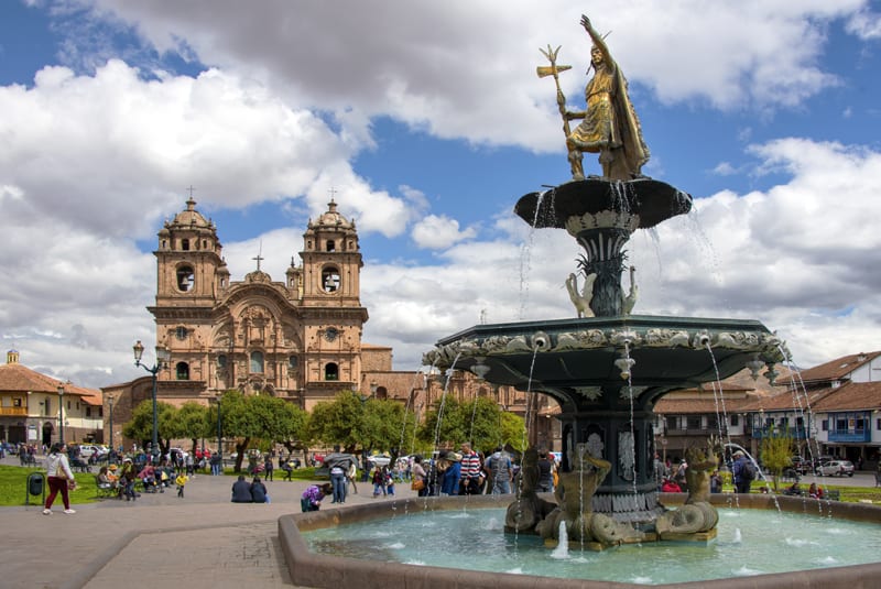 A tsatue of an Inca and a cathedral seen in Cusco and the Sacred Valley in Peru