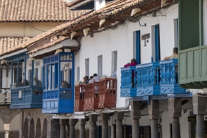 people on wooden balconies on buildings seen in Cusco and the Sacred Valley in Peru