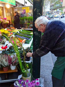 a man buying flowers in an outdoor flower market