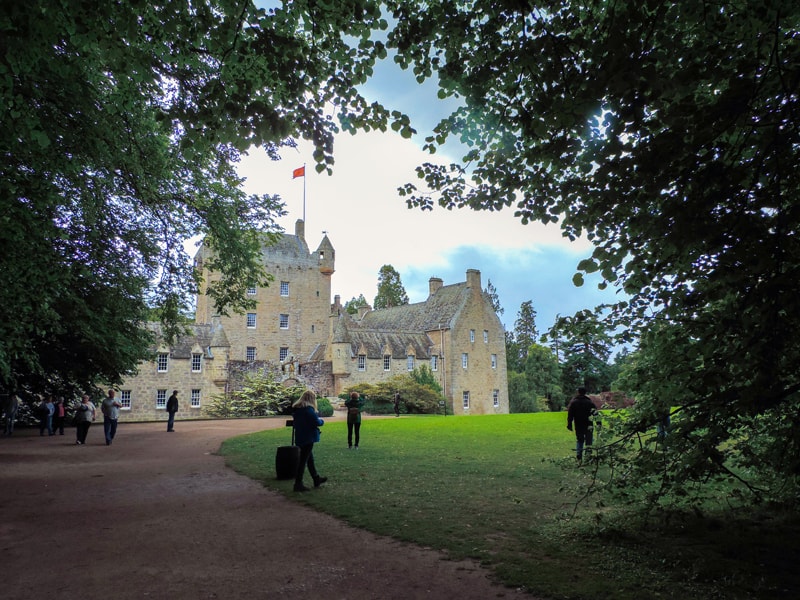 people outside a castle seen on a Highlands of Scotland road trip