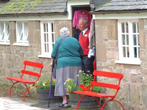 man and woman standing by bright red benches seen on a Highlands of Scotland road trip