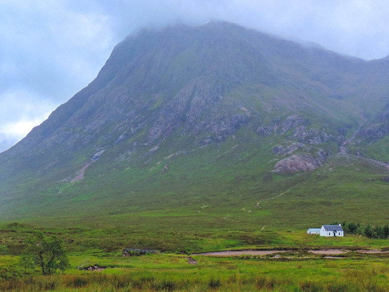 a small white house in fron of a mountain