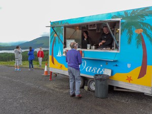 people by a roadside food truck