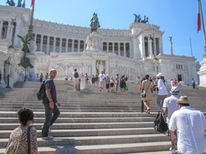 people on the steps of a large monument see on walks in Rome