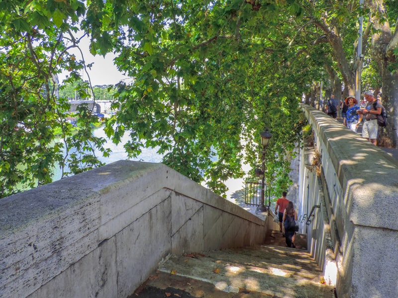 people walking down  stair alongside a river