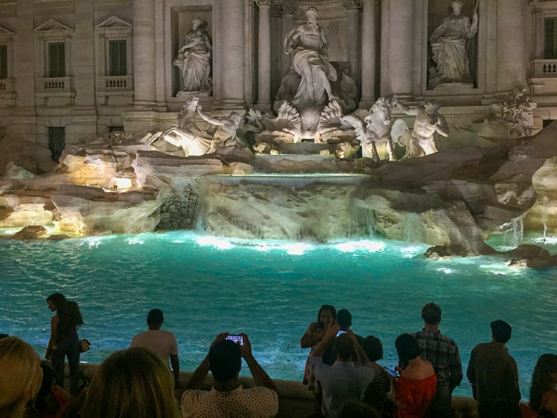 people at a large fountain at night seen on walks in Rome