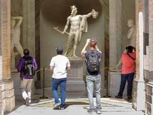 a man taking a photo of a statue in a museum