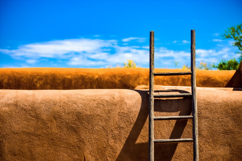 a ladder against an adobe wall