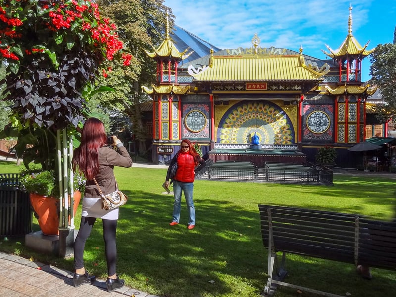 A young woman taking a photo in Tivoli Gardens