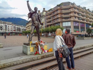 people looking at a statue of Freddy Mercury