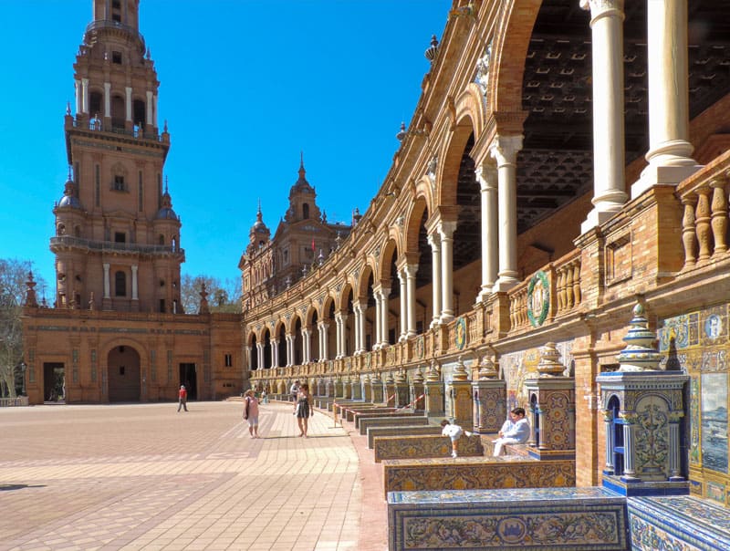 people sitting under the pillars of an ornate building