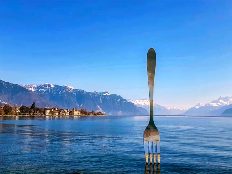 a large fork sculpture in a lake