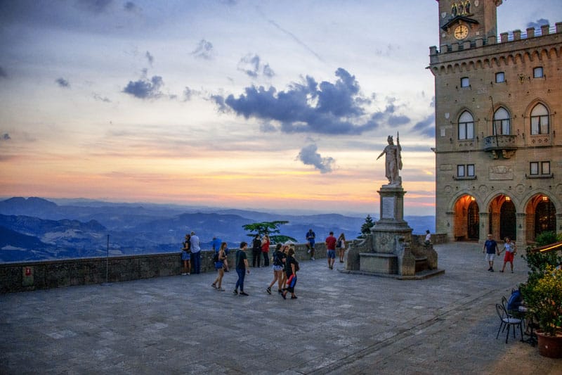 people walking near a statue on a plaza, one of the things you'll see when you visit San Marino