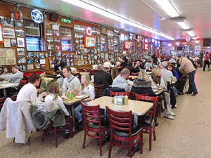 people at tables in one of the delis in New York City