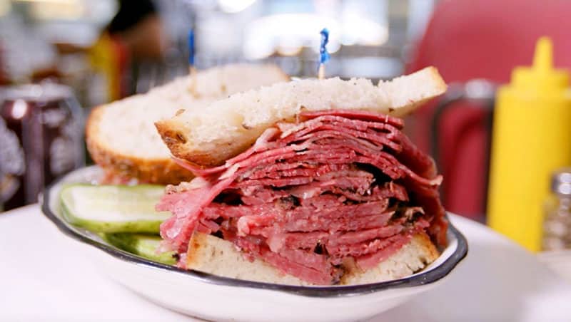 a pastrami sandwich on a plate in one of the delis in New York City