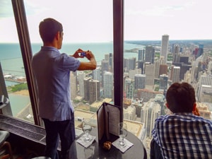 man taking a photo of a city from a tall building