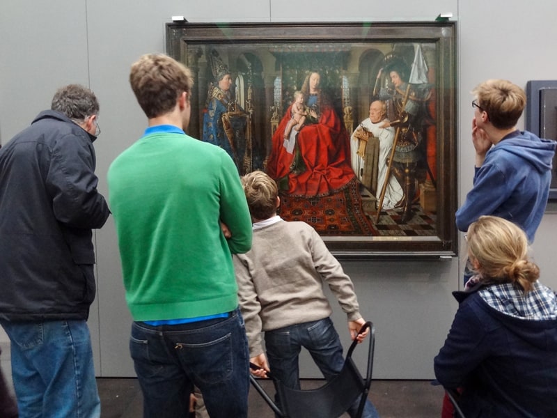 people looking at a painting in one of the places to visit in Belgium