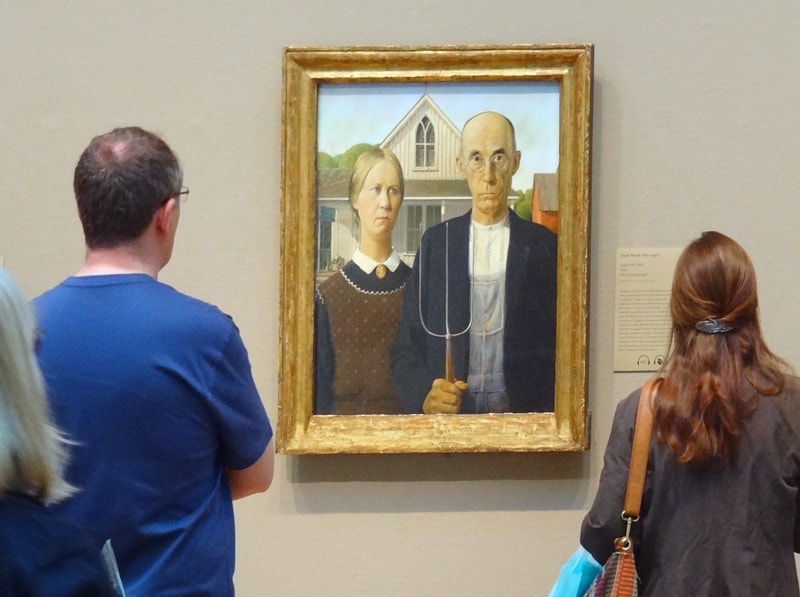 a couple looking at a painting in a museum