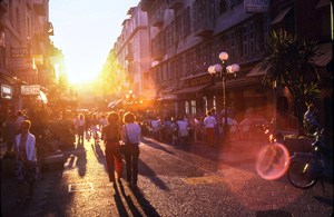 people on a street at sunset