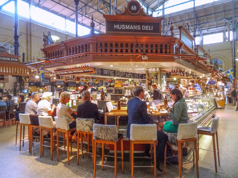 people sitting at a counter in a food hall