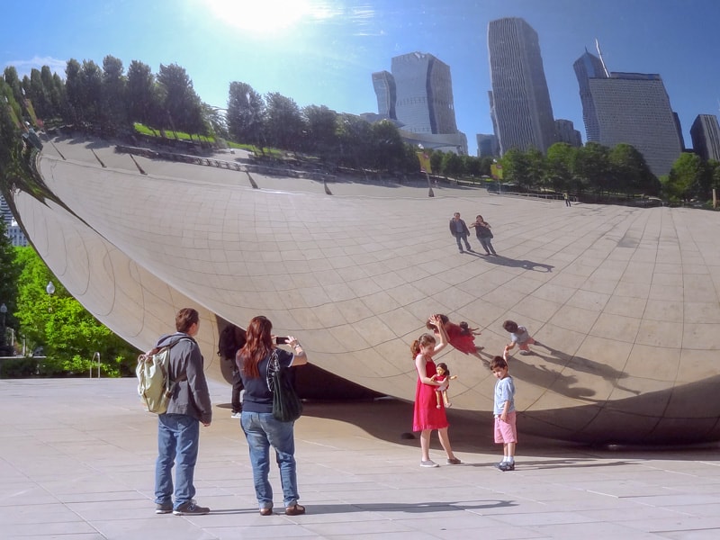 a family by a huge mirror sculpture, one of the things to do in Chicago