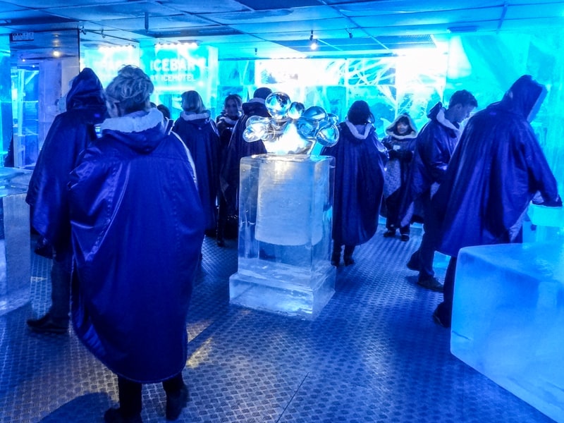 people in blue parkas by blocks of ice