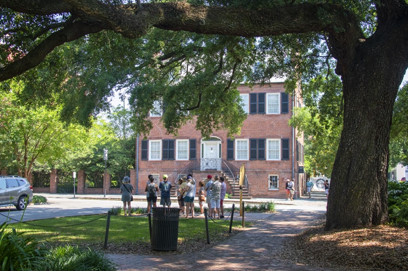 people looking at a historical house, one of the things to do in Savannah