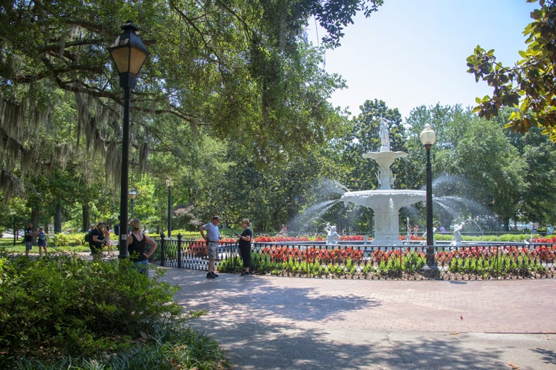 people enjoying a park with a fountain, one of the things to do in Savannah