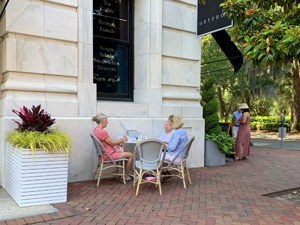 woman sitting at a table outside a restaurant