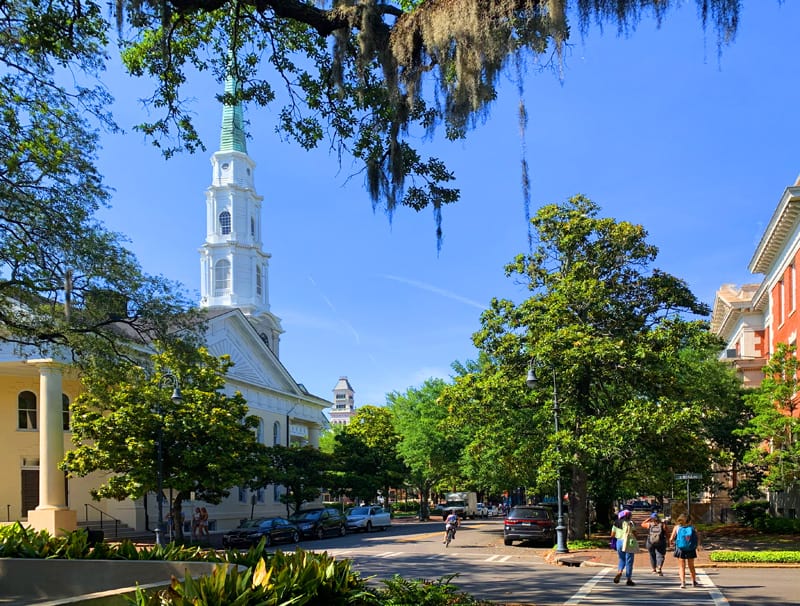 people strolling by a church with a white steeple, one of the things to do in Savannah